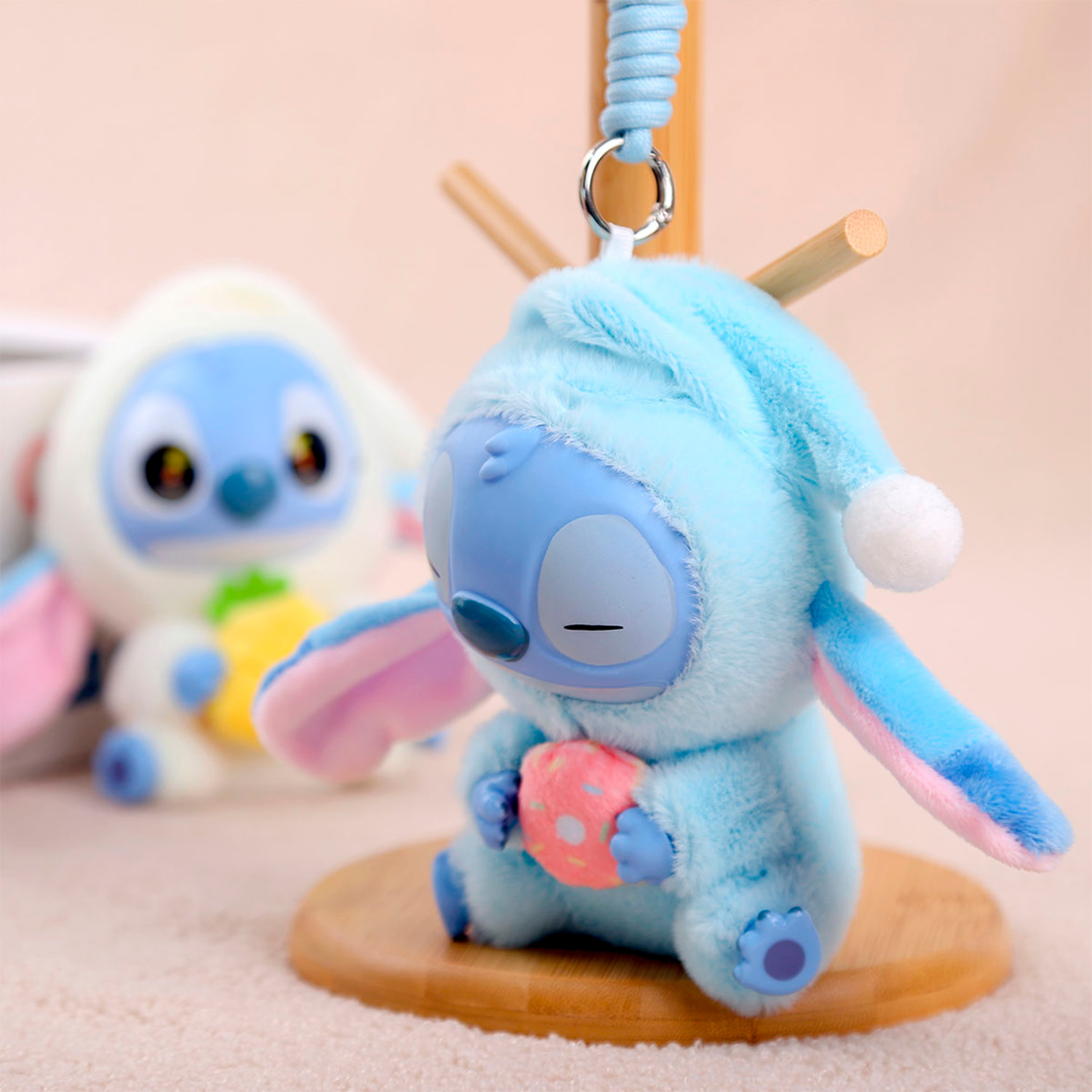 Peluche extrasuave y mullido con colgante. Diseño de monstruito en pijama. 15 cm.