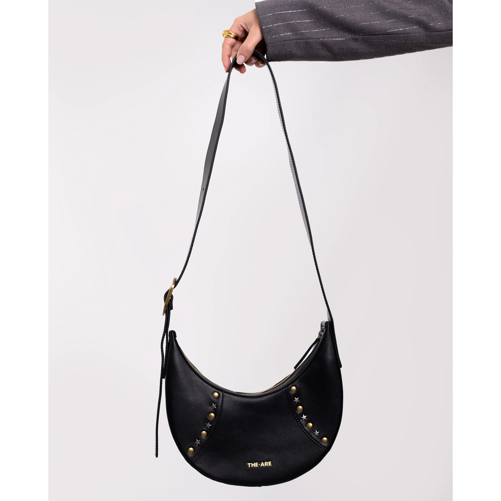 Bolso con forma de media luna y tachuelas