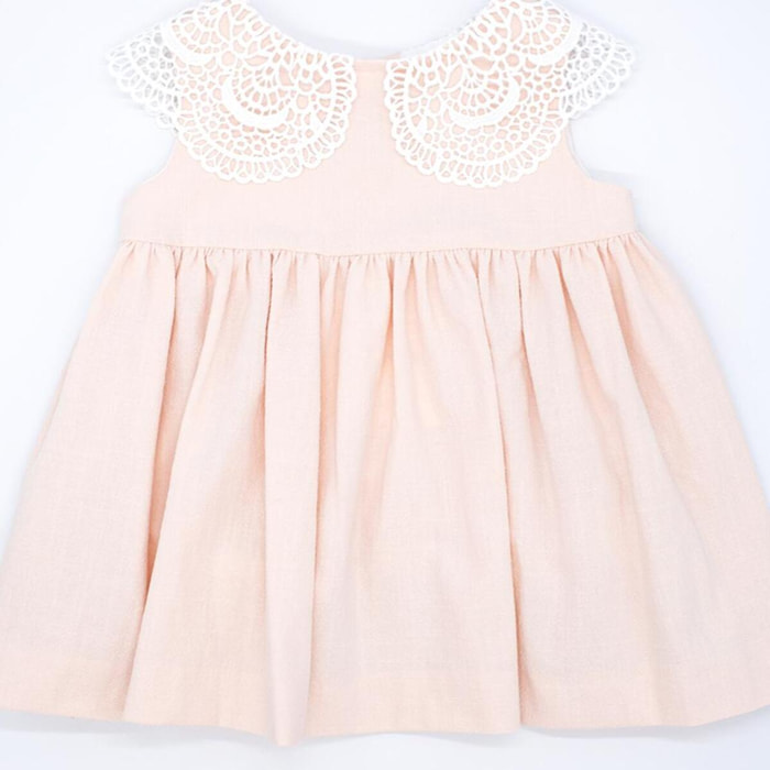 Vestido corto rosa, falda fluncida y cuello de guipur blanco.