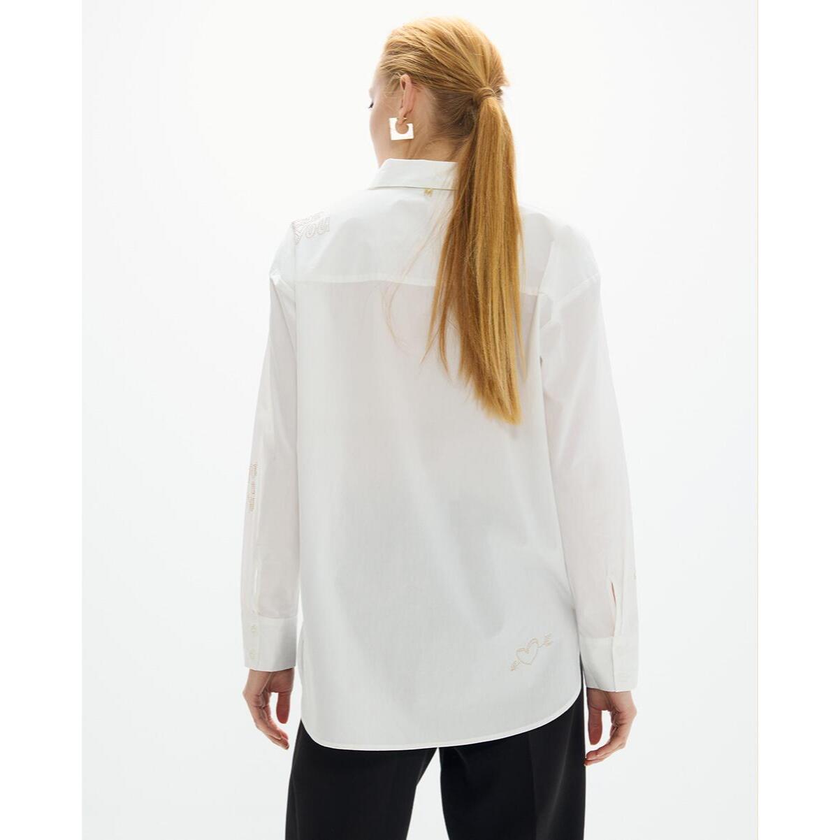 Camicia oversize con borchie dorate e disegni posizionati strategicamente.
