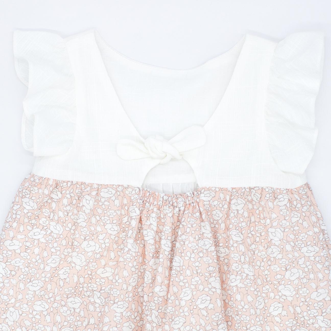 Vestido con el cuerpo en blanco y falda estampada de flores albaricoque. Con volantes en las sisas, falda fruncida de volantes.