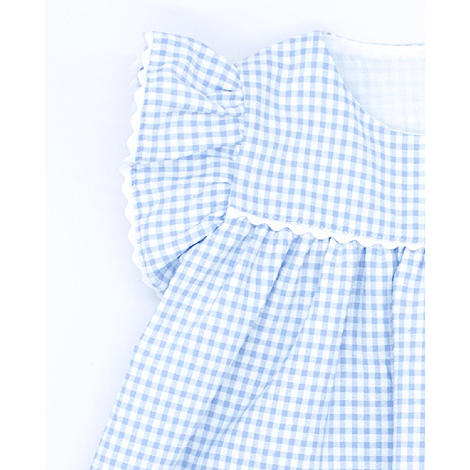 Vestido corto estampado de cuedro vichy azul, volantes en las sisas, bolsillos y falda fruncida.