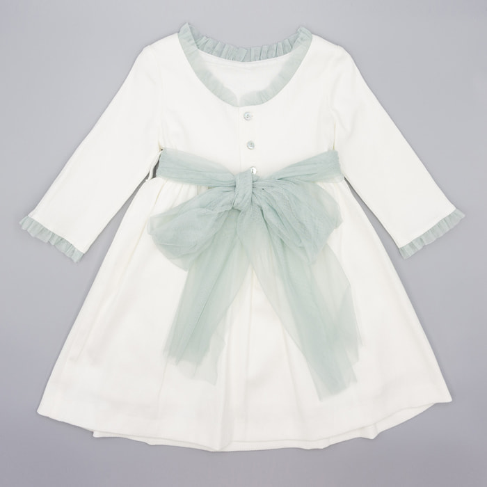 Vestido de pique blanco, con volantes en cuello y puños, y lazada en tul verde.