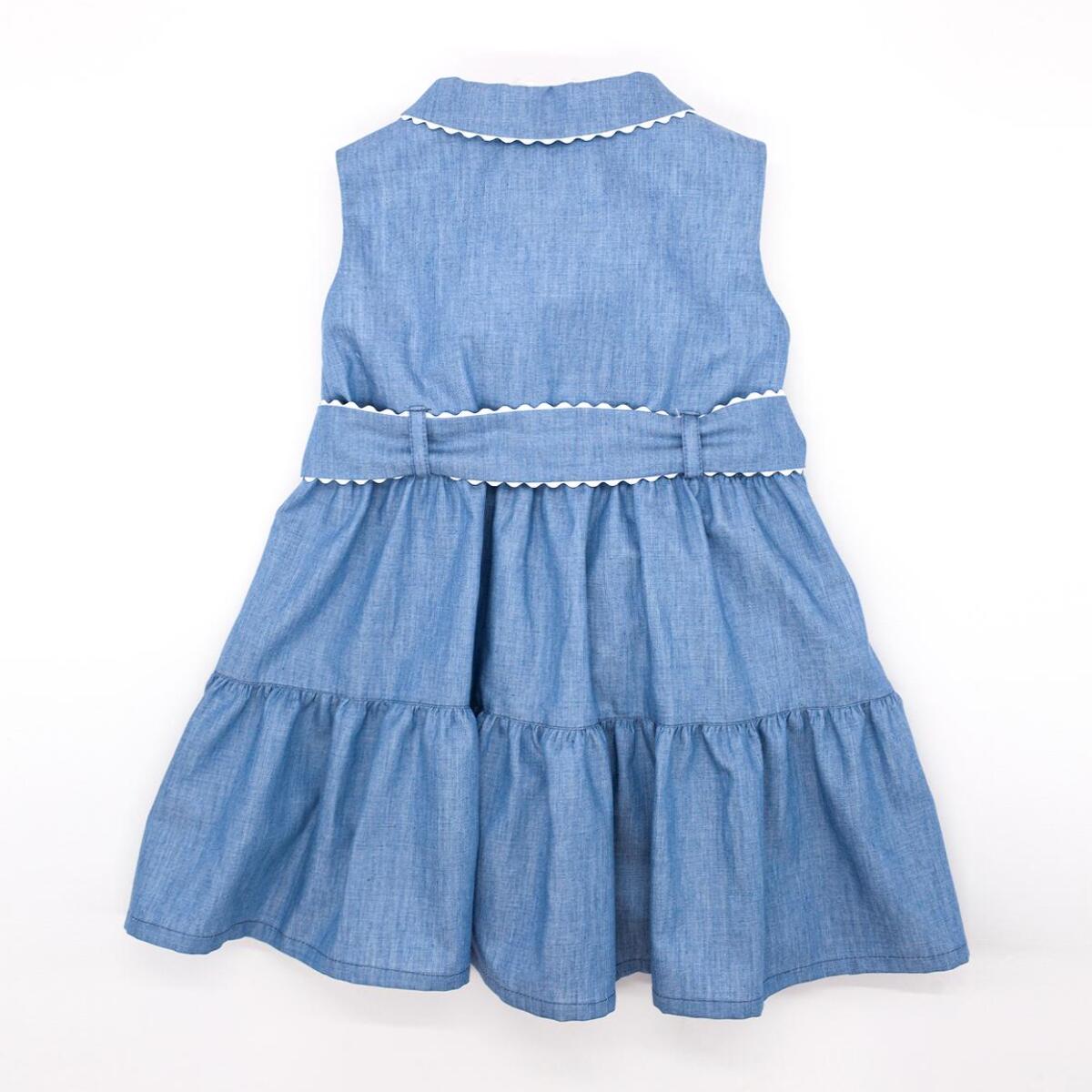 Vestido camisero azul. Falda de volantes, cuello y cinturon terminado en picunela. Botones en el centro.