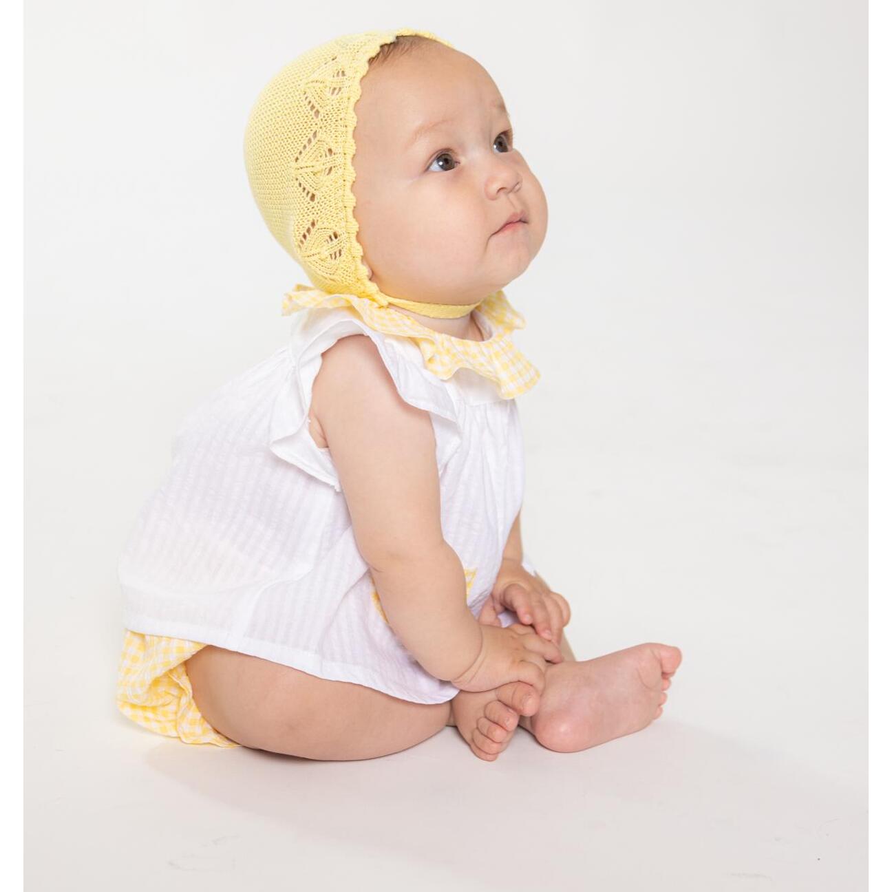 Blusa blanca con bolsillos y volante en el cuello de vichy amarillo, volantes en las sisas. Lazo en el bolsillo.