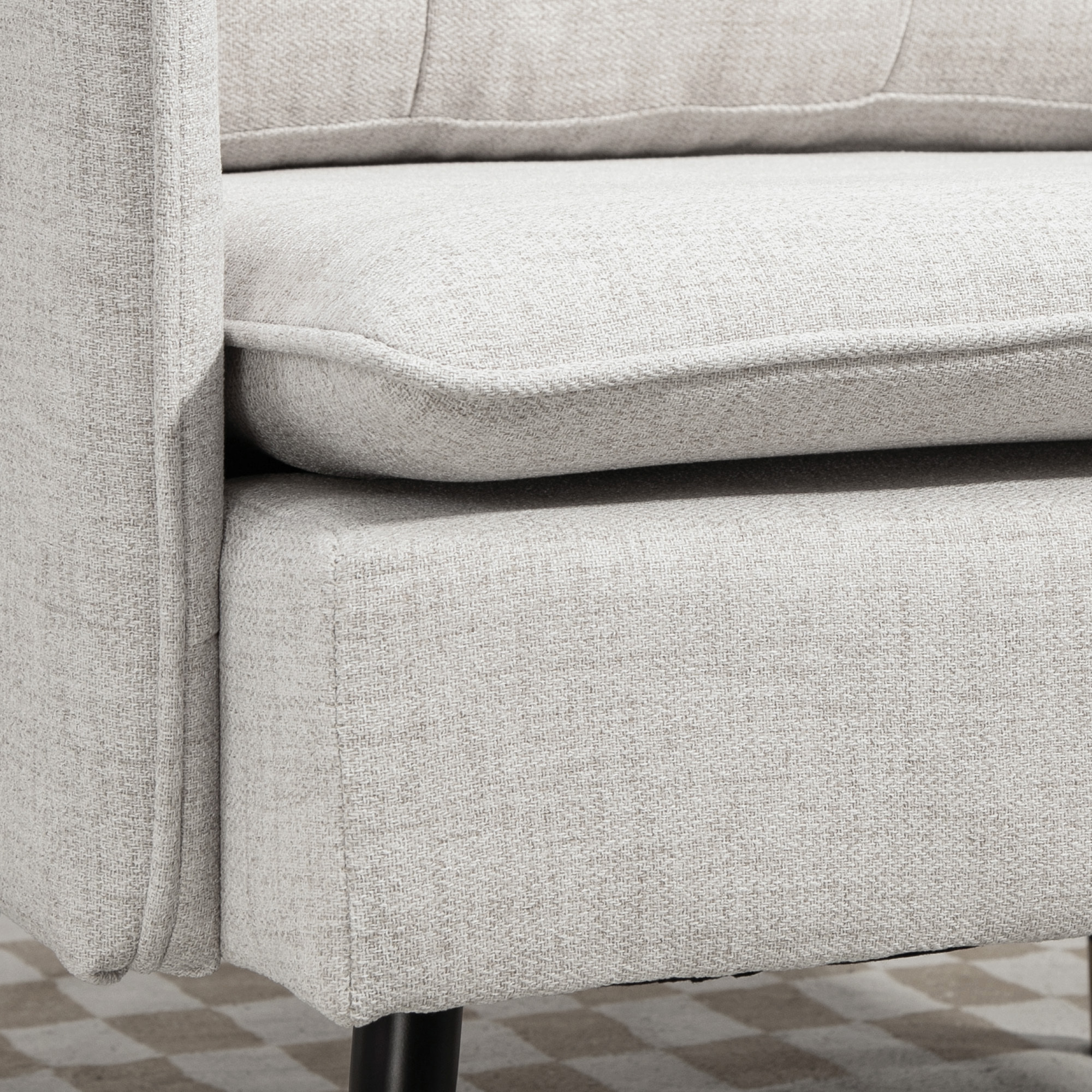 Fauteuil style art-déco dossier effet capitonné piètement incliné effilé métal noir extrémités dorées tissu blanc cassé