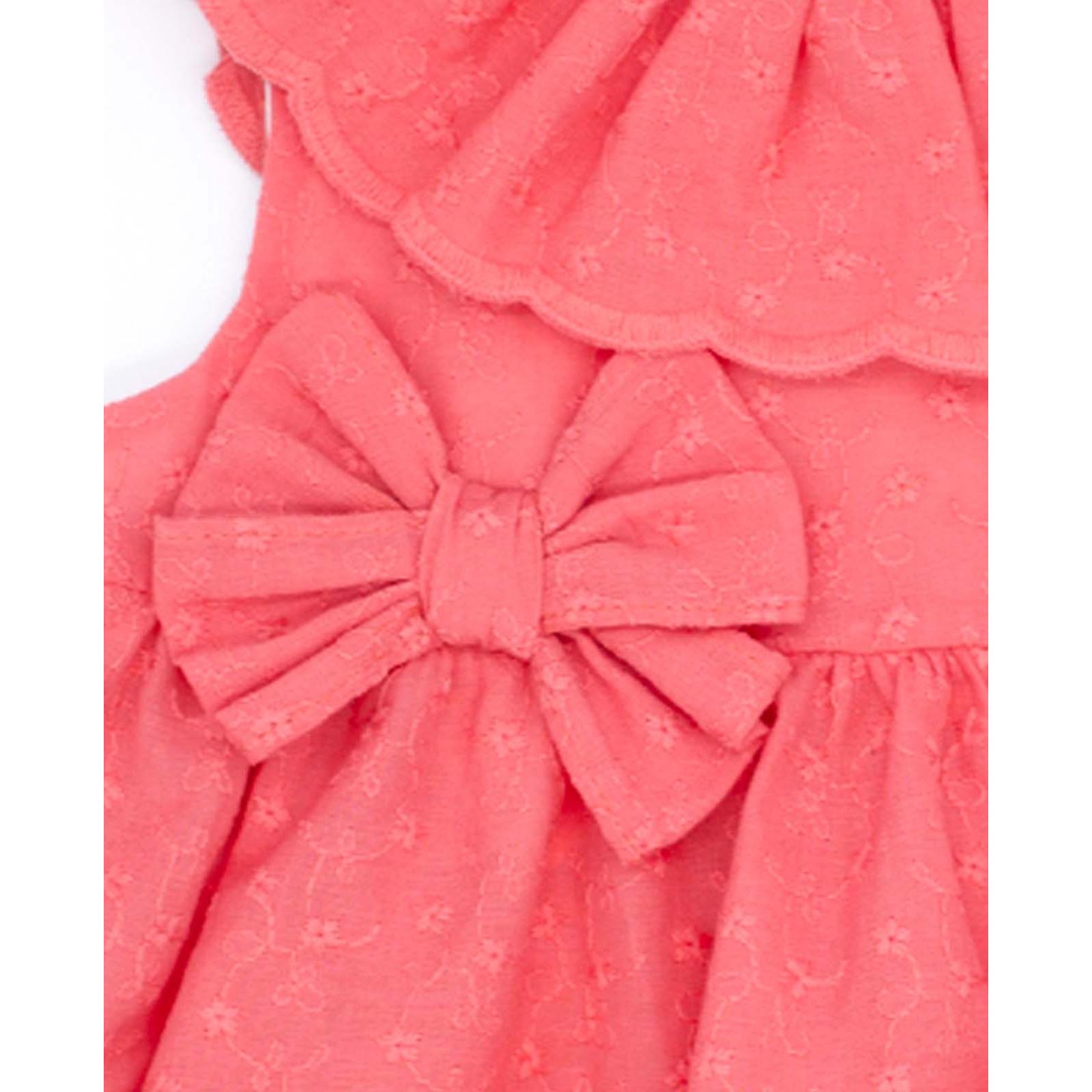 Vestido corto bordado coral, volante en el cuello y falda fruncida. Lazo en la cintura.