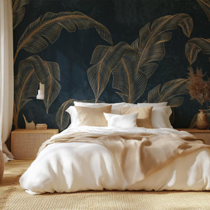 Papier peint tropical chic feuilles dorées fond bleu nuit Intissé