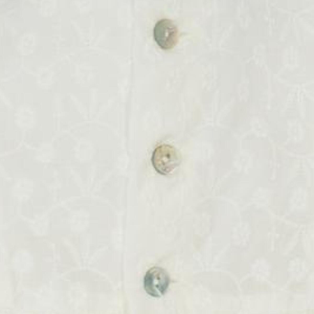 Vestido corto blanco bordado, volantes en la sisa y lazo rosa.