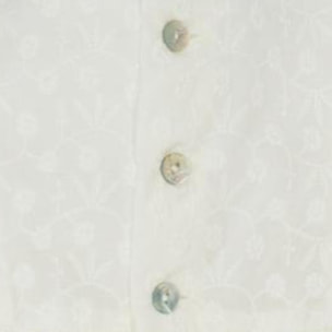 Vestido corto blanco bordado, volantes en la sisa y lazo rosa.