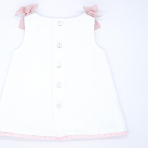 Vestido de piqué blanco con detalle de puntillas rosas.