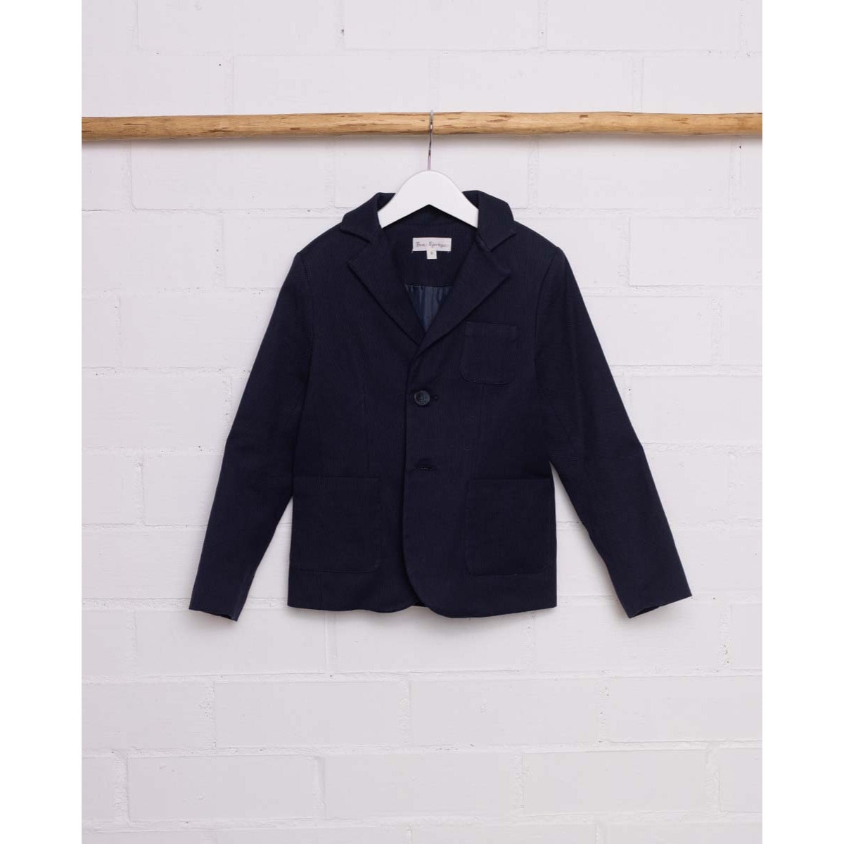 Blazer azul marino. Con tres bolsillos exteriores, botones en los puños y el centro.