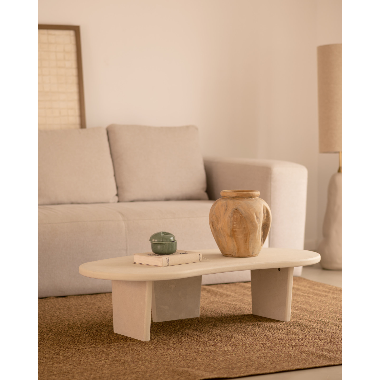 Table basse en microciment aux formes organiques avec trois pieds de teinte blanc cassé de 120cm Hauteur: 30 Longueur: 120 Largeur: 59.4