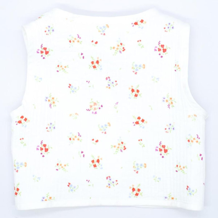 Chaleco crudo con flor roja, cinta para atar en el delantero.