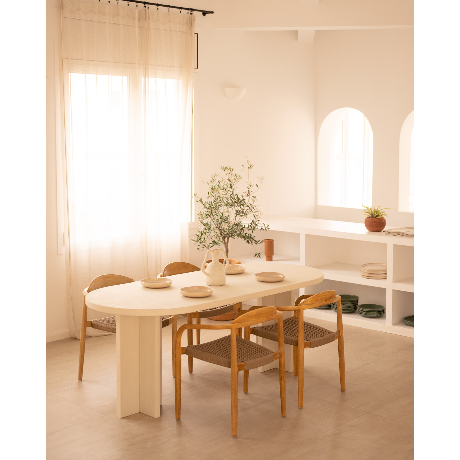 Table de salle à manger ovale en microciment de teinte blanc cassé disponible en différentes tailles