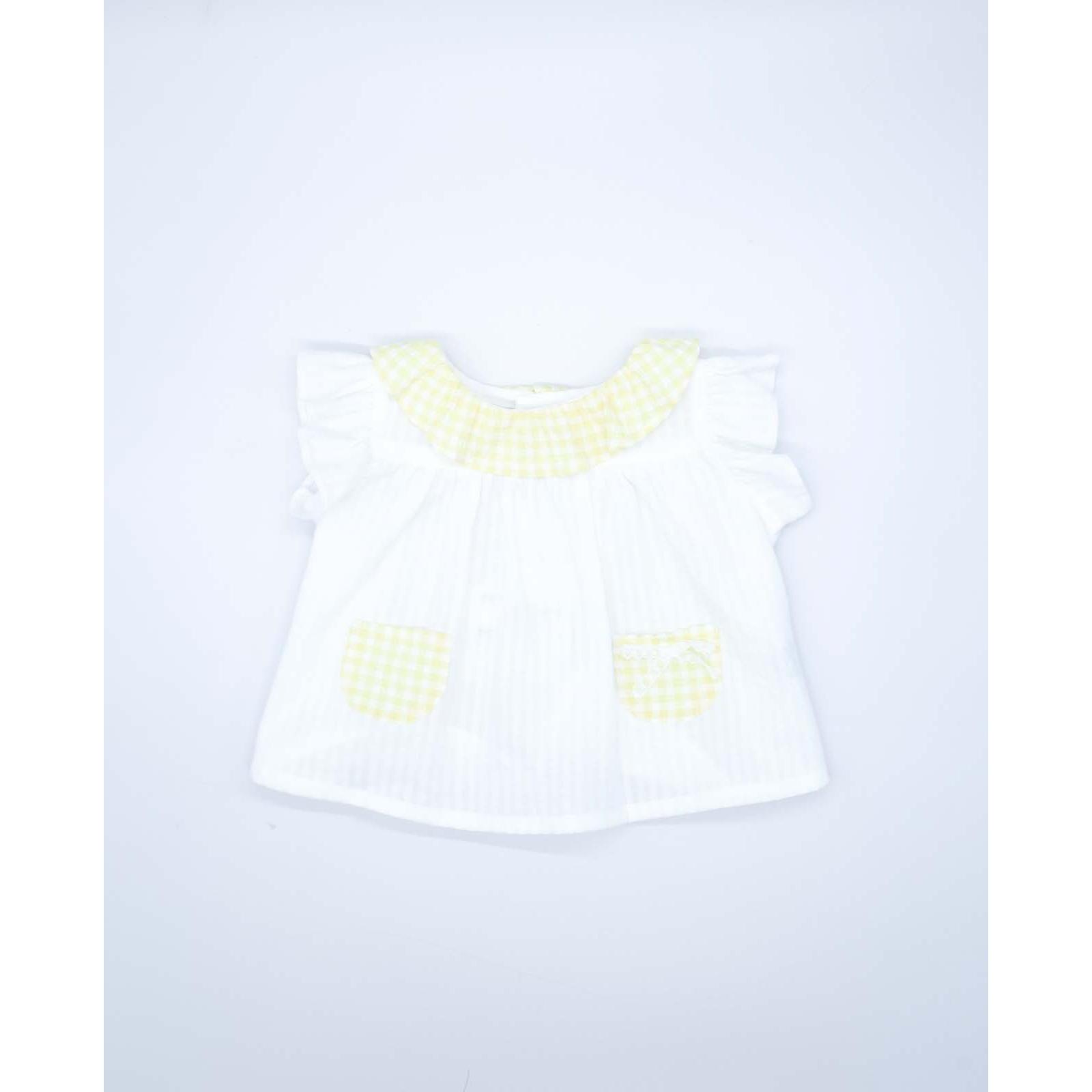Blusa blanca con bolsillos y volante en el cuello de vichy amarillo, volantes en las sisas. Lazo en el bolsillo.