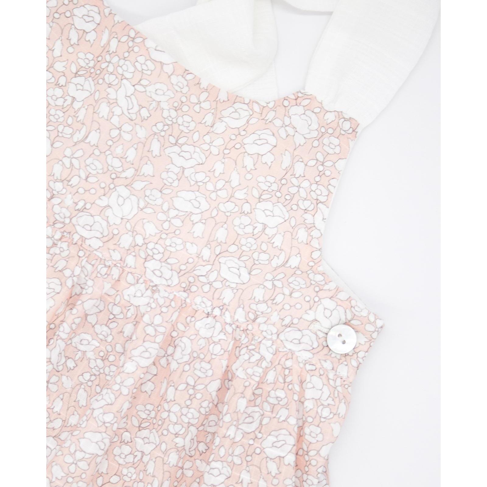 Vestido midi de flor rosa. Falda de volantes y tirantes cruzados en la espalda.