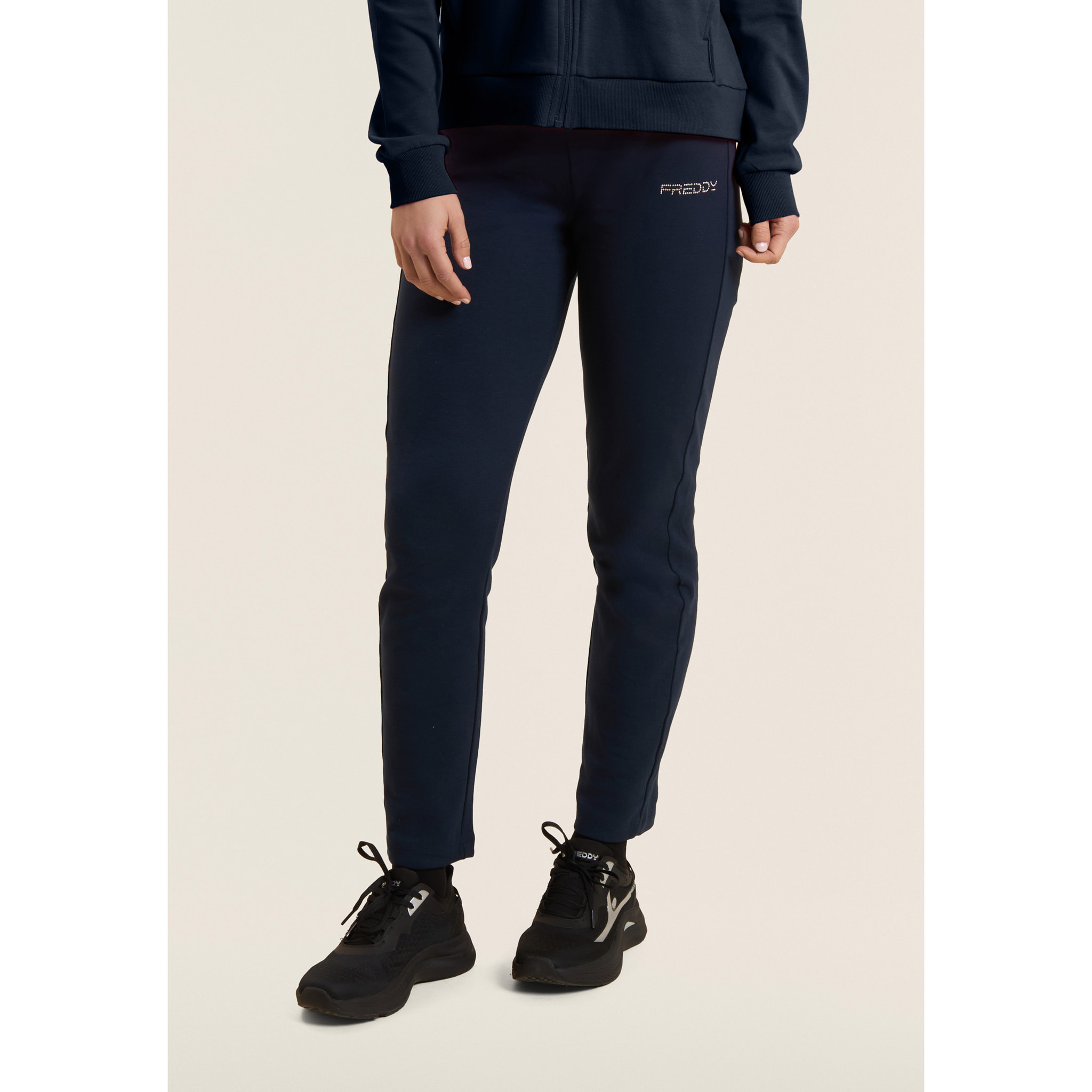 Tuta con zip e collo alto, logo in perline