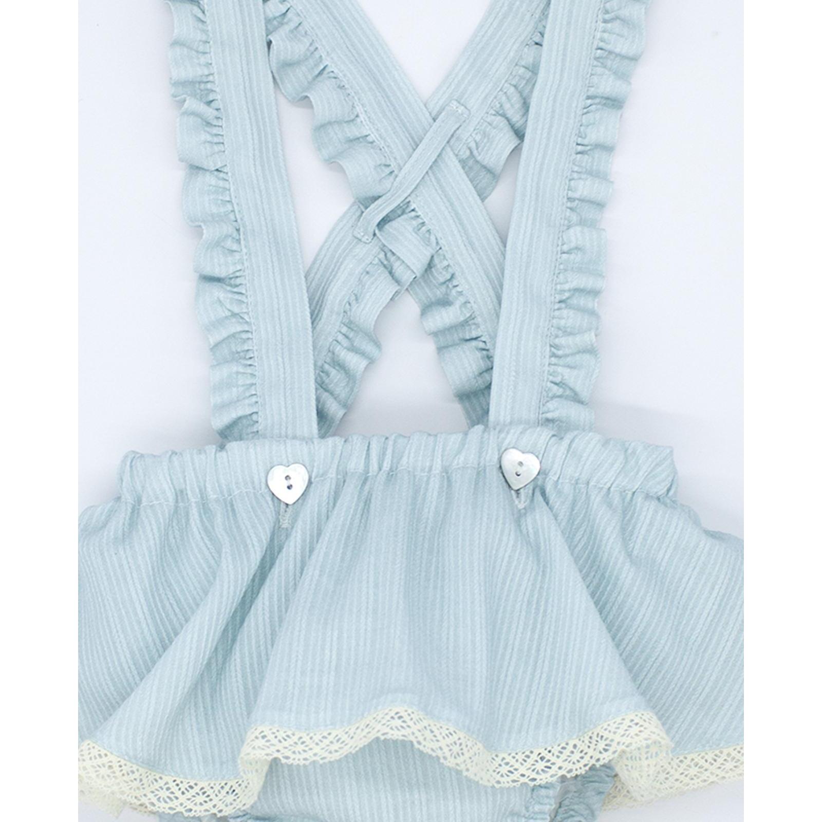 Cubrepañal con falda y tirantes con volantes.