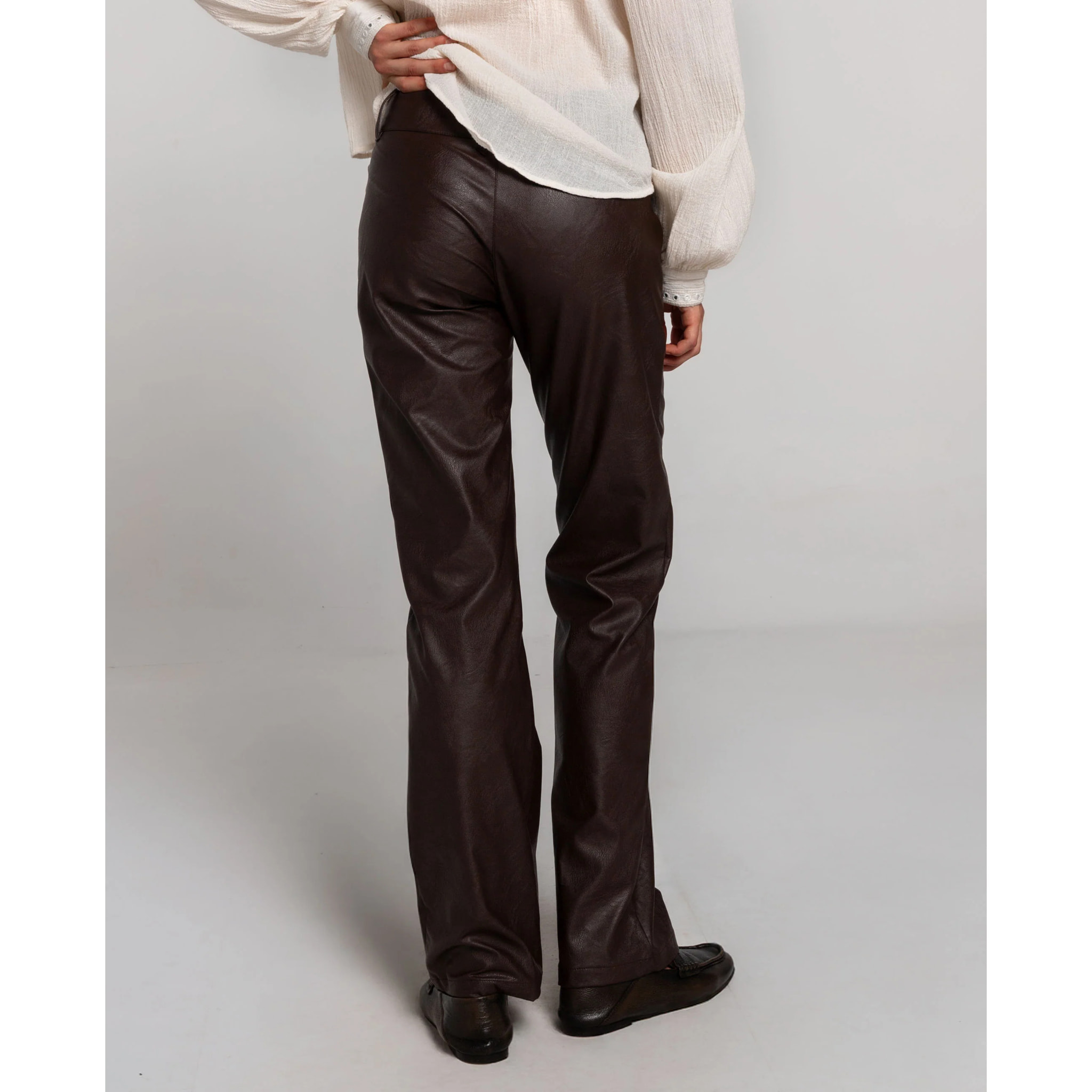 Pantalón de polipiel marrón con bragueta, doble botón y bolsillos.