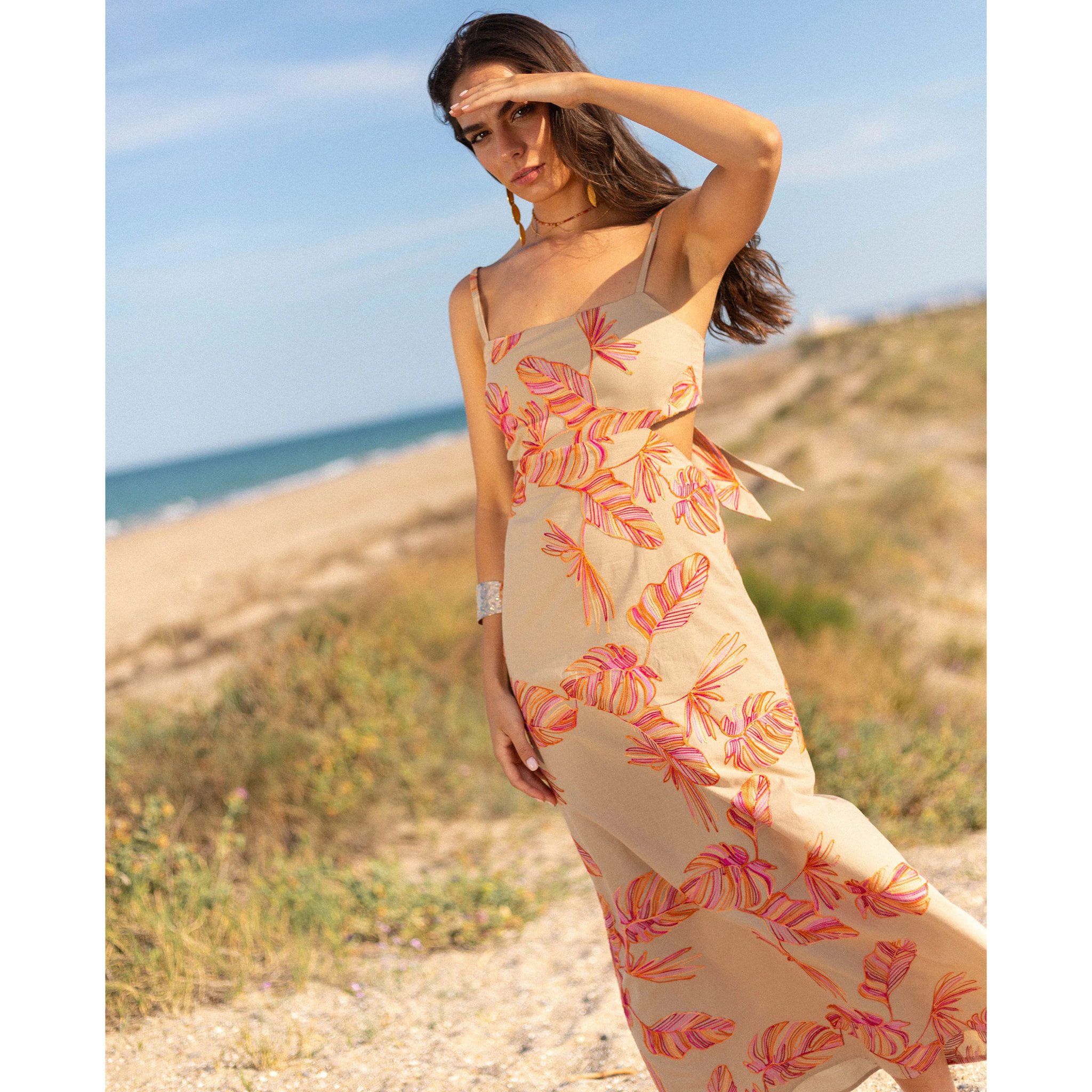 Vestido midi con bordado floral, espalda descubierta y lazada ajustable.