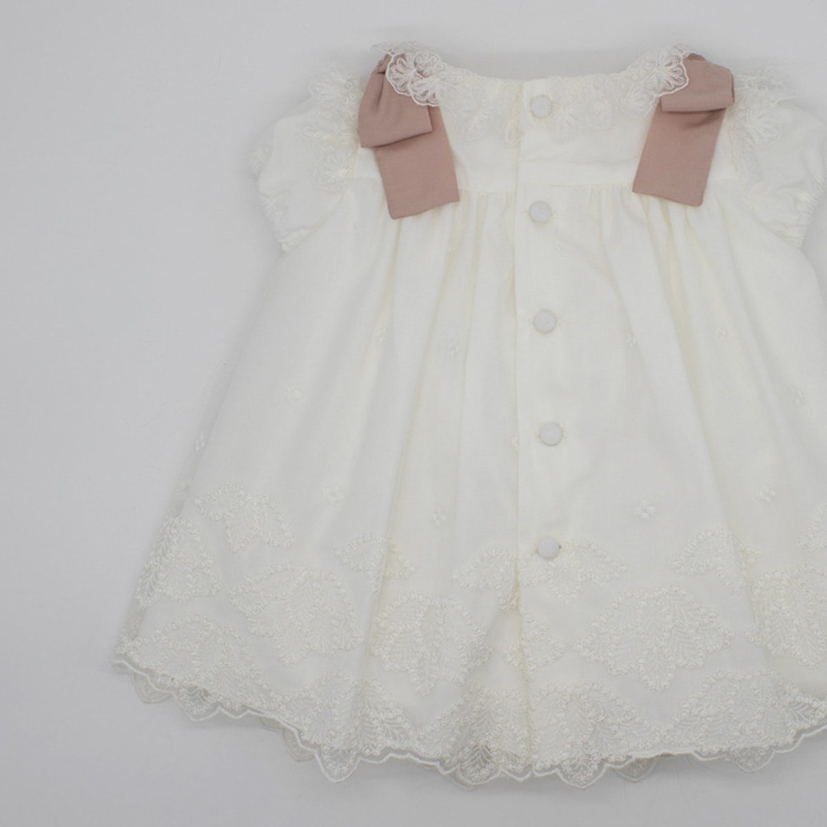 Vestido bordado de tul avalorio. Puntilla en el cuello y en las sisas, manga corta abullonada.