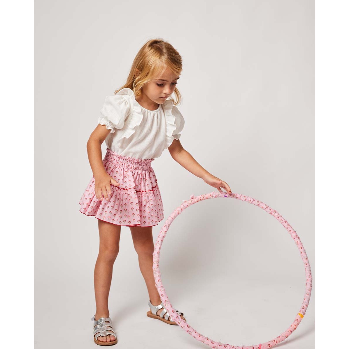 FALDA CON VOLANTE ROSA CON FLORES ROJAS