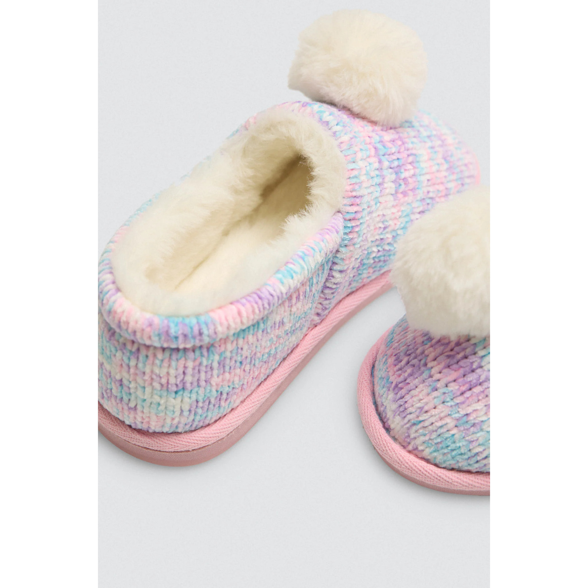 Pantofole colorate con pompon e tessuto intrecciato