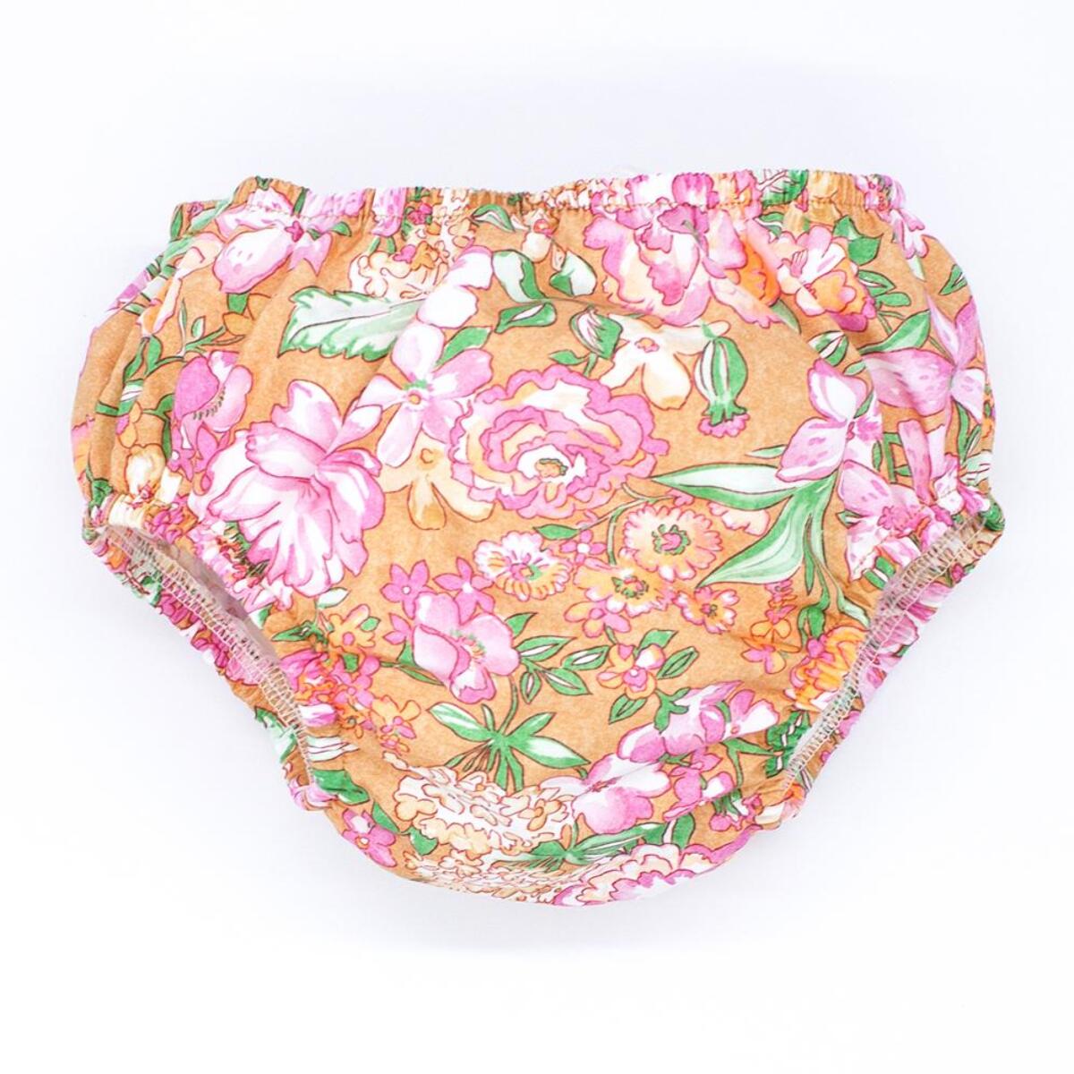 Cubrepañal de popelín ocre estampado de flores rosas. Elastico en la cintura y en las piernas.