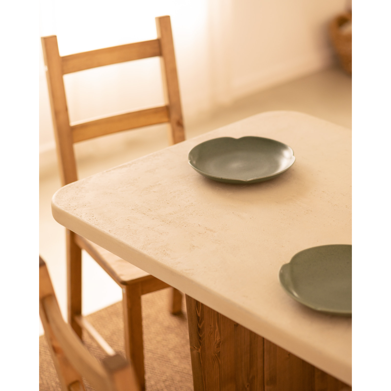 Table de salle à manger en microciment de couleur blanc cassé avec des pieds en bois de chêne foncé en différentes tailles