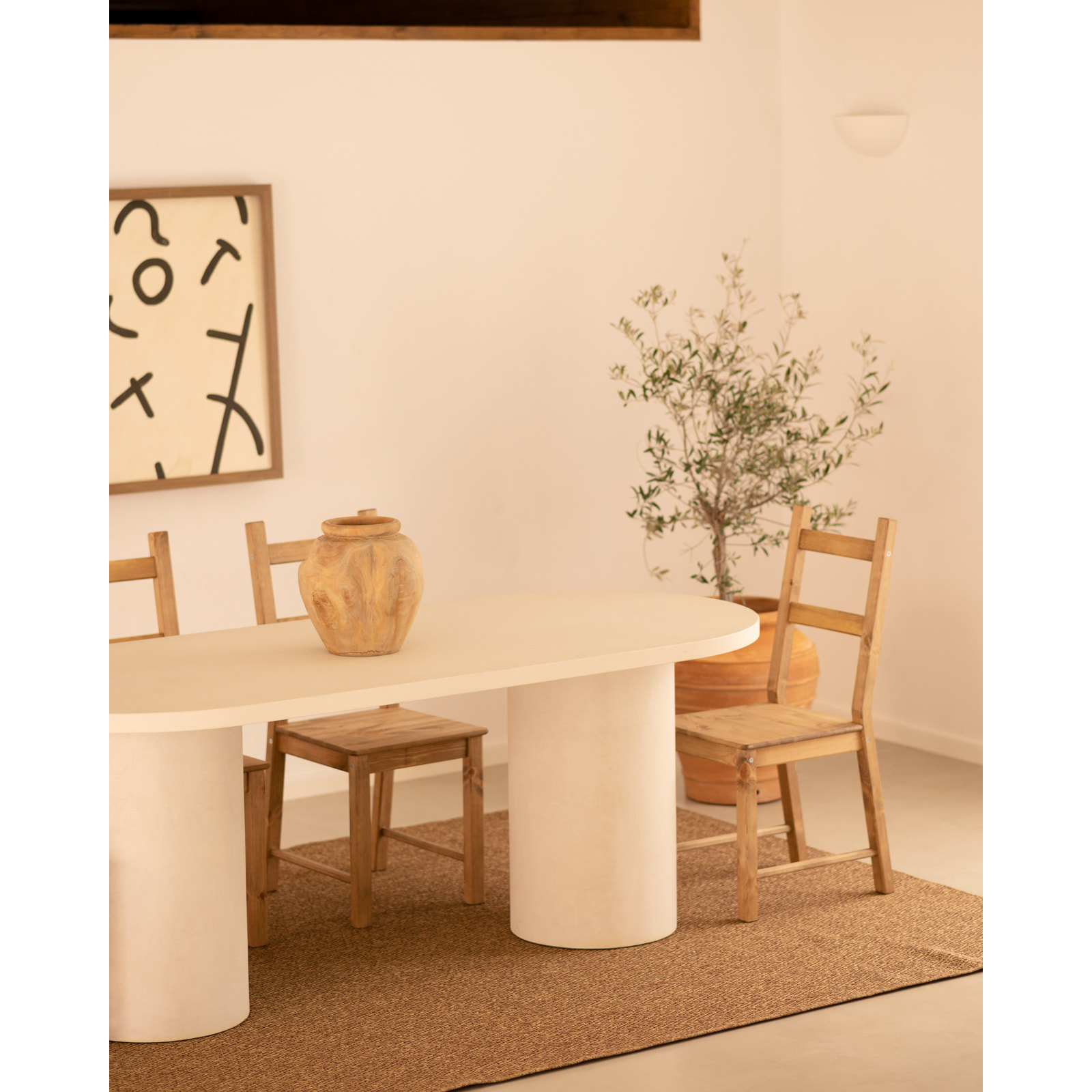 Table de salle à manger ovale en microciment de teinte blanc cassé disponible en différentes tailles