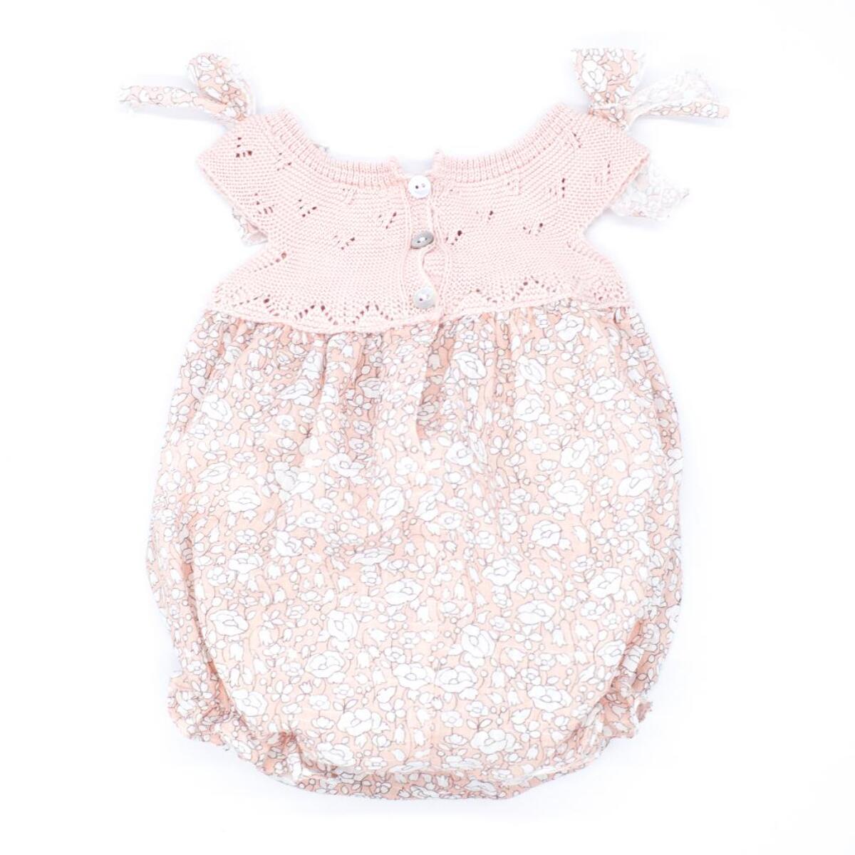 Pelele estampado de flores rosas y cuerpo de punto, lazos en el hombro.