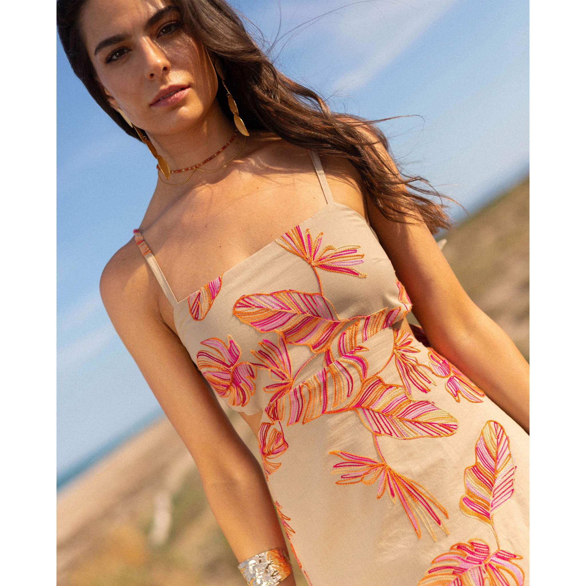 Vestido midi con bordado floral, espalda descubierta y lazada ajustable.