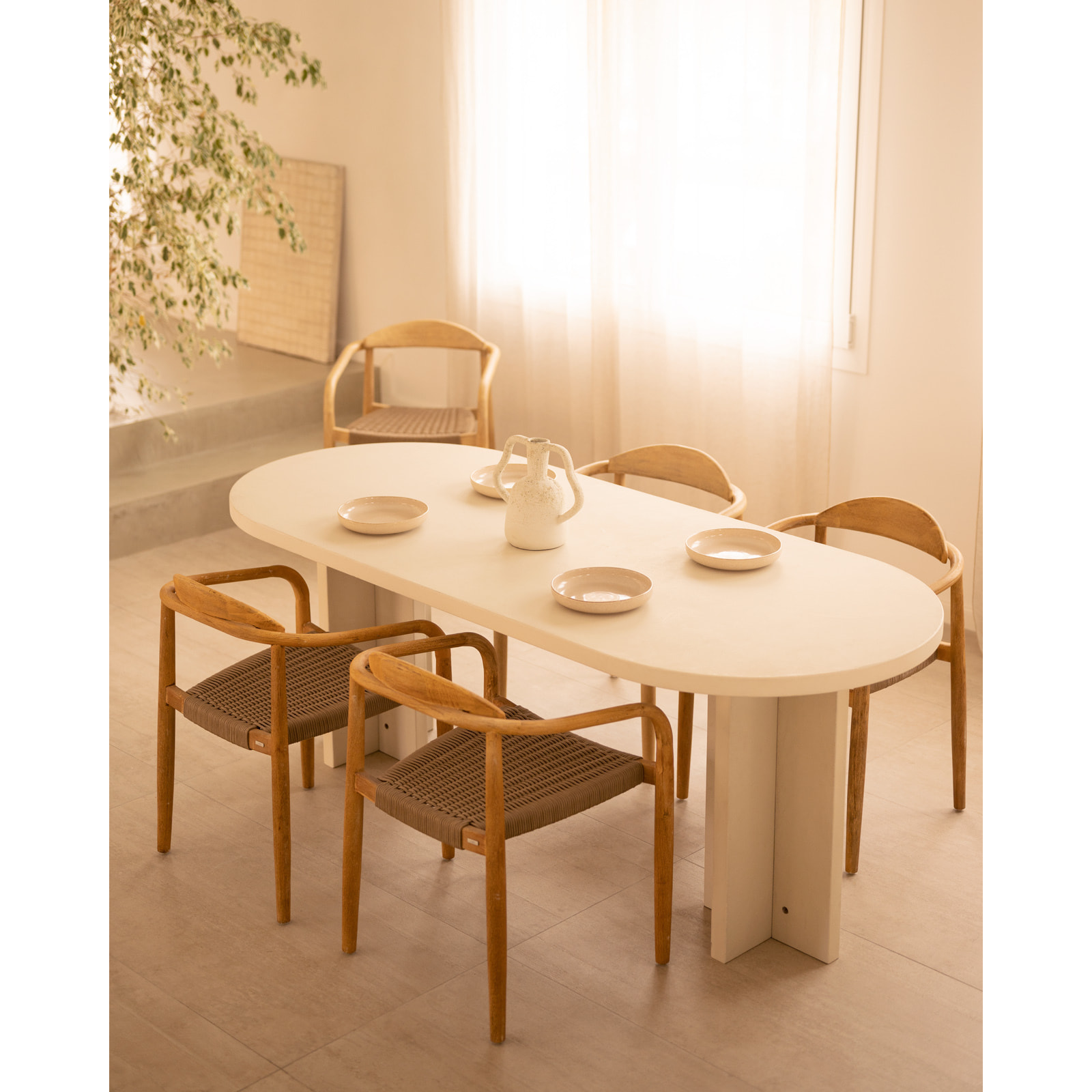 Table de salle à manger ovale en microciment de teinte blanc cassé disponible en différentes tailles