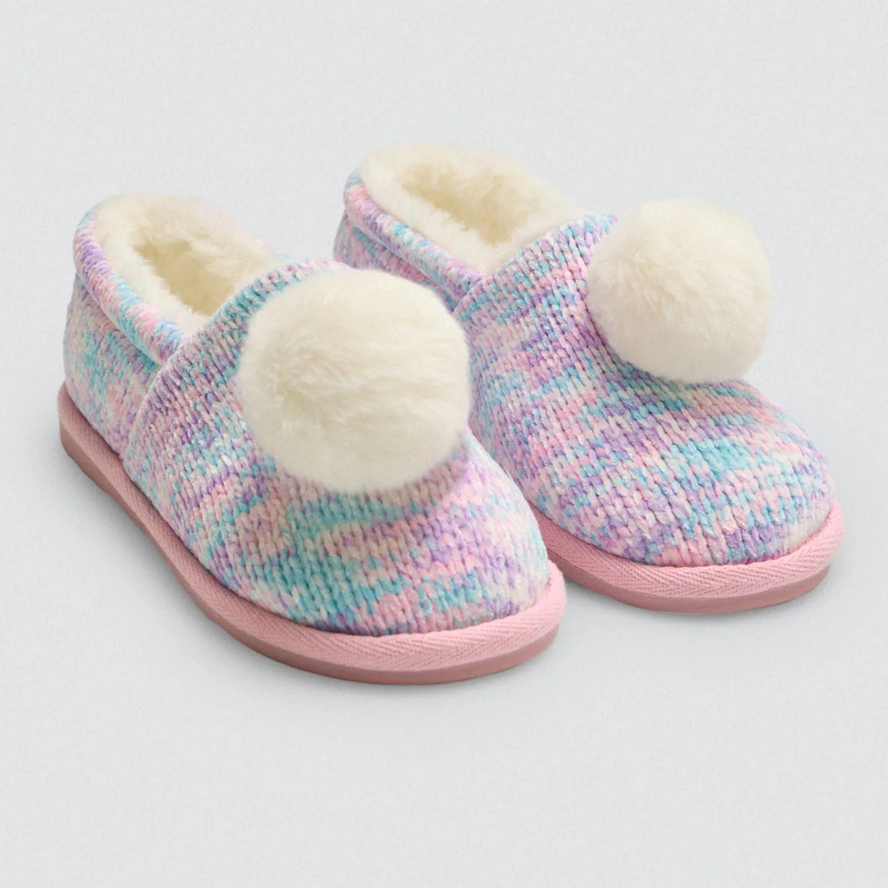 Pantofole colorate con pompon e tessuto intrecciato