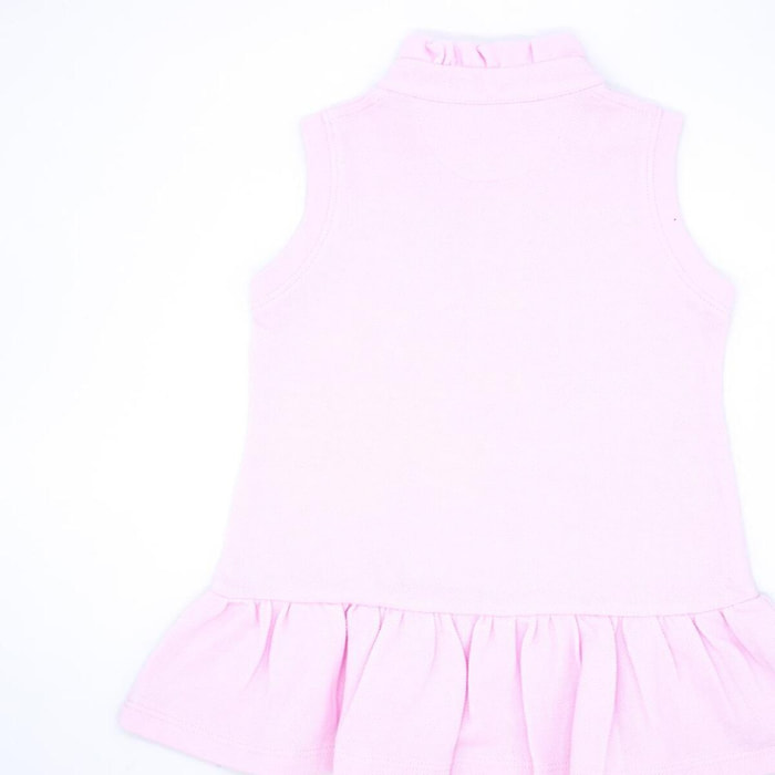 Vestido de polo rosa, sin mangas con volante en el cuello y en el bajo.