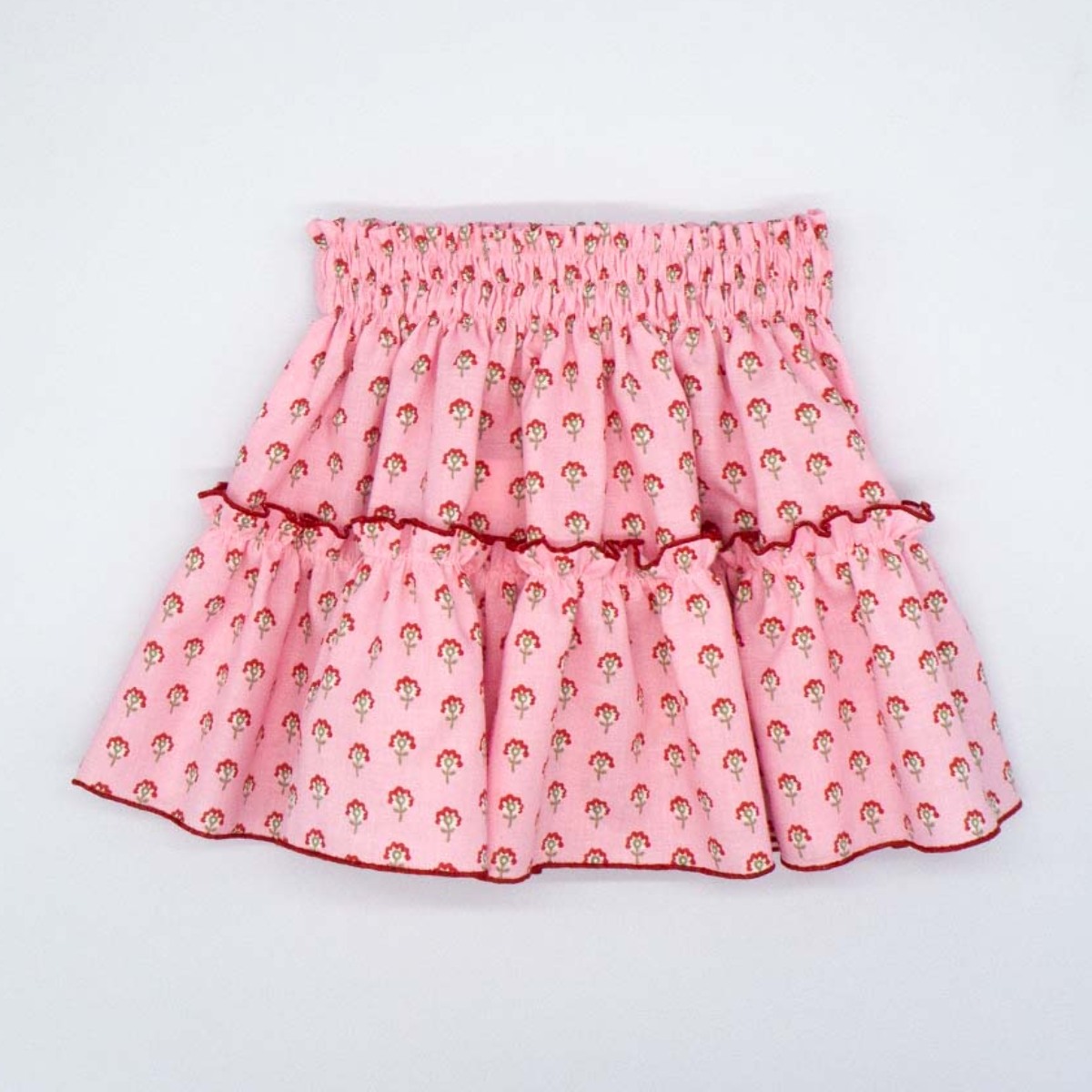 FALDA CON VOLANTE ROSA CON FLORES ROJAS