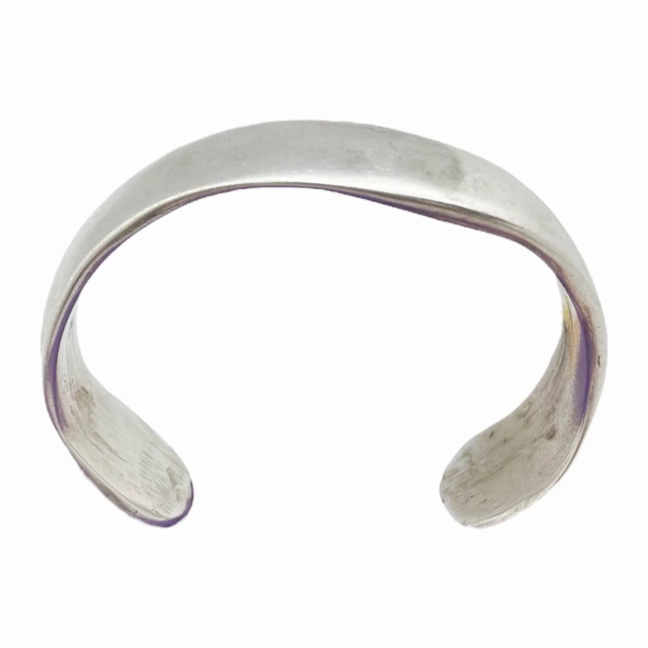 Pulsera rígida en zamak chapado plata en forma de aguas. Abierta no ajustable