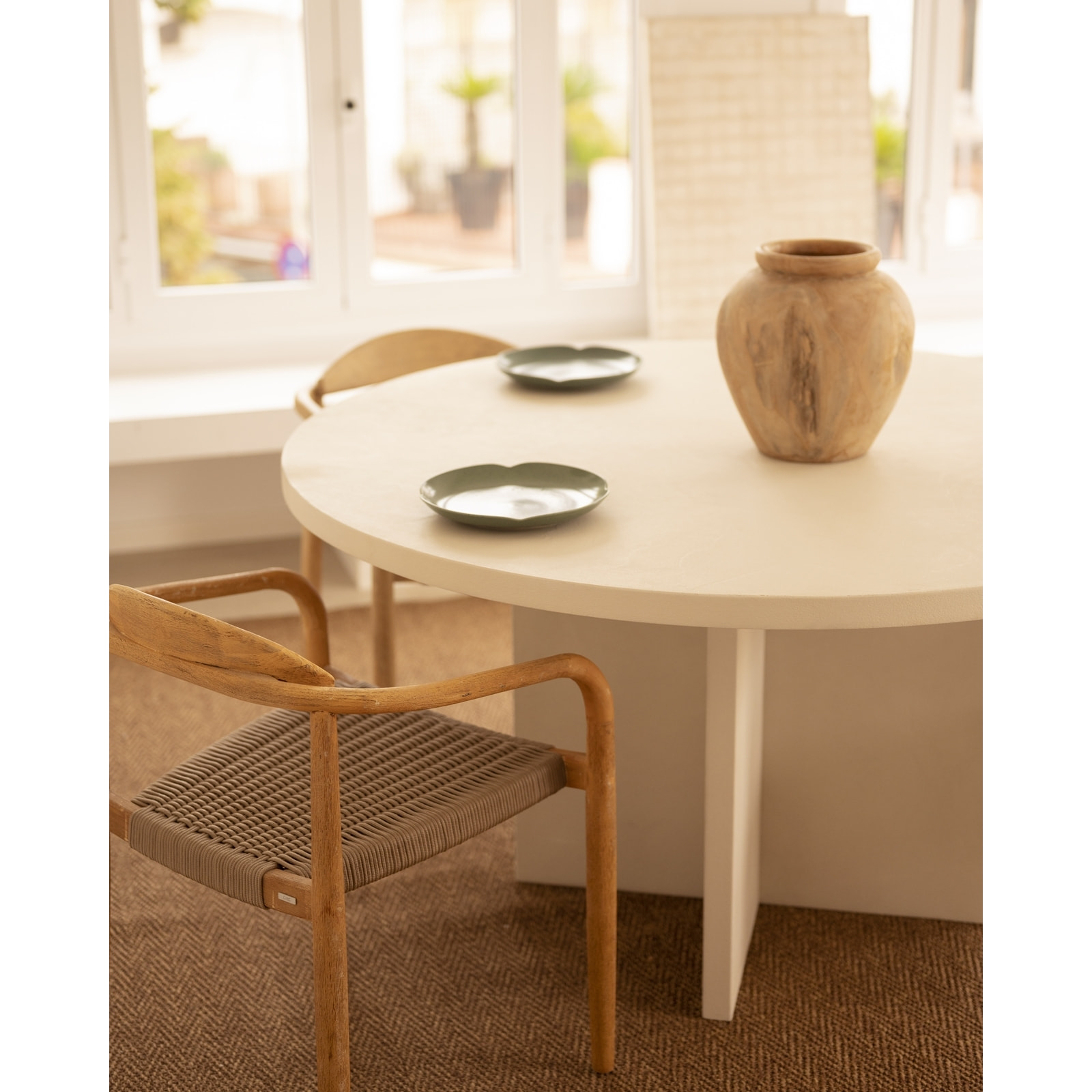 Table de salle à manger ronde en microciment de teinte blanc cassé disponible en différentes tailles