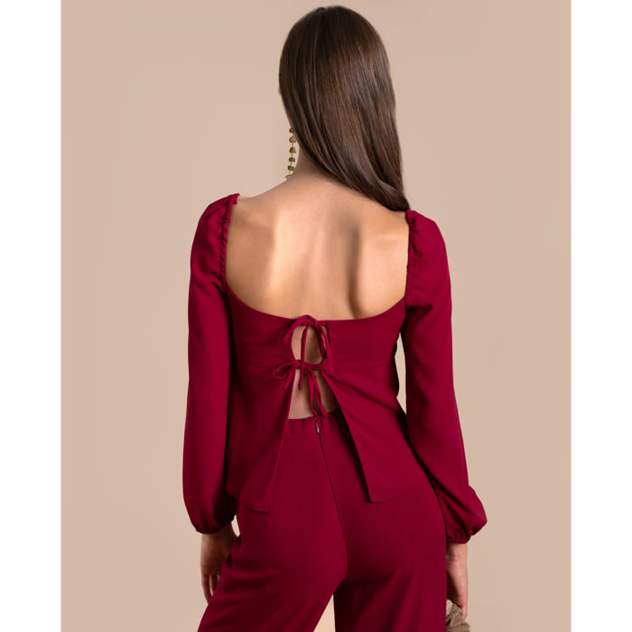Blusa de manga larga con lazos en la espalda.